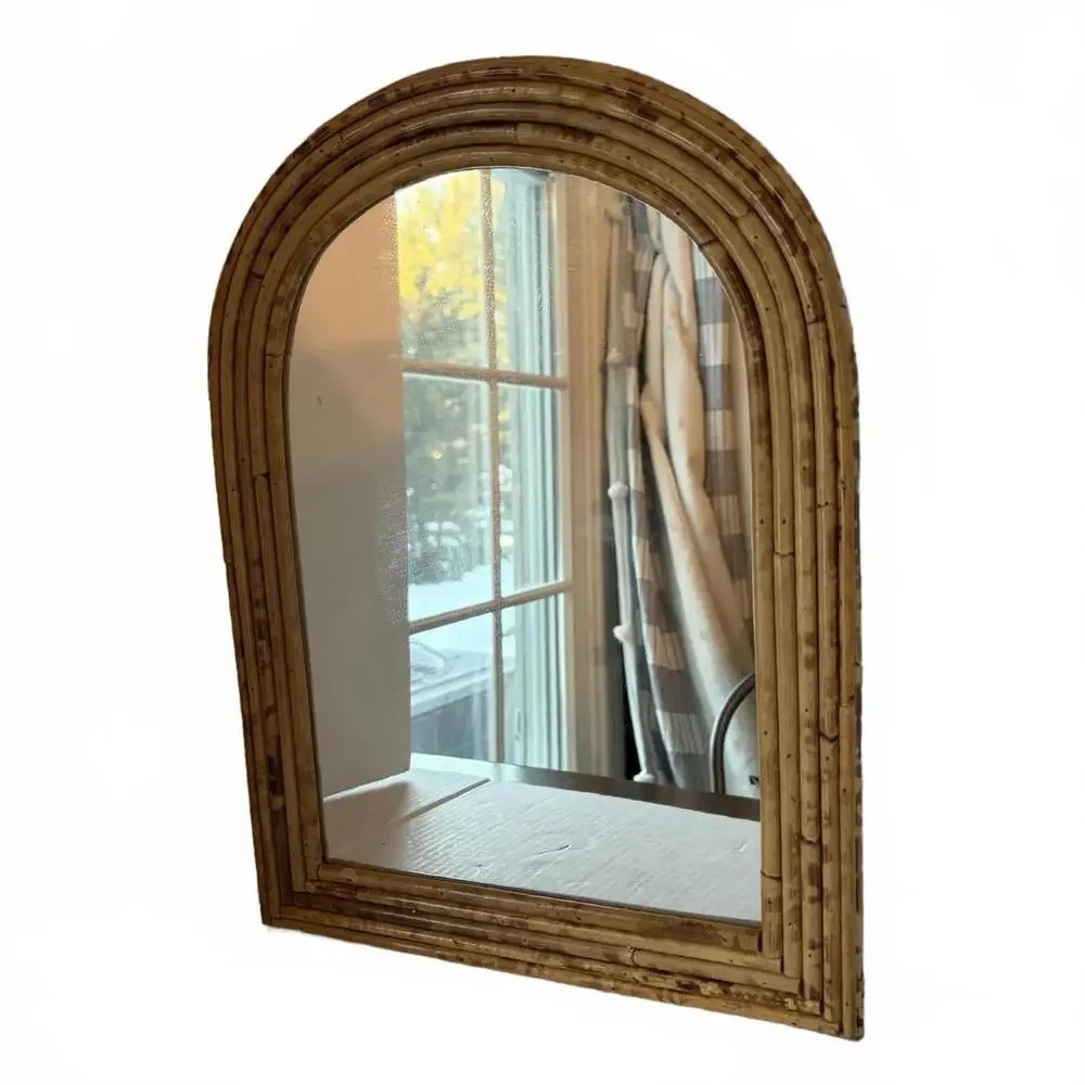 Vintage Arched rattan mirror with a natural, aged finish.